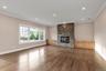 Unfurnished living room featuring ornamental molding, hardwood / wood-style flooring, a stone fireplace, and recessed lighting