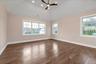 Spare room with dark wood-style floors, healthy amount of natural light, vaulted ceiling, ceiling fan, and recessed lighting