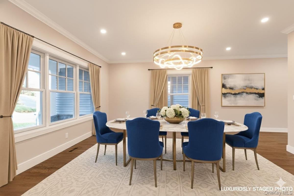 Dining space featuring dark wood finished floors, ornamental molding, a chandelier, and recessed lighting