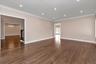 Spare room with a chandelier, recessed lighting, dark wood-style flooring, stairway, and crown molding