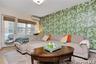 Living room featuring wallpapered walls, an AC wall unit, and wood finished floors