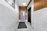 Entryway with elevator, tile patterned floors, and tile walls