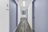 Hall with dark wood finished floors and a skylight