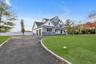 View of front of house featuring stone siding, driveway, and a porch