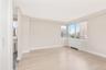 Unfurnished room with radiator, plenty of natural light, light wood-style flooring, and a city view