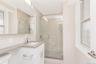 Full bathroom featuring a stall shower, vanity, and tile walls