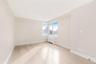 Unfurnished room with radiator heating unit, light wood-style flooring, and a view of city