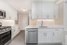 Kitchen featuring stainless steel appliances, tasteful backsplash, and white cabinetry