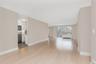 Unfurnished living room featuring light wood-type flooring and baseboards