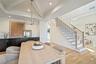 Dining room with beam ceiling, light wood finished floors, stairway, a chandelier, and recessed lighting