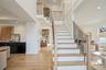 Staircase featuring a decorative wall, wood finished floors, wainscoting, recessed lighting, and a high ceiling