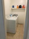 Laundry area with light tile patterned floors and independent washer and dryer