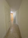 Corridor featuring light tile patterned flooring and baseboards