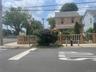 View of asphalt road with sidewalks, curbs, a gate, and traffic signs