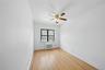 Unfurnished room with light wood finished floors, radiator, ornamental molding, and ceiling fan