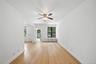 Spare room featuring light wood-type flooring, a ceiling fan, radiator heating unit, and crown molding