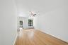 Spare room featuring light wood-style floors, radiator, and ceiling fan