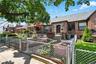 View of front of house featuring a gate, a fenced front yard, a patio, and brick siding