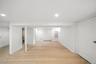 Finished basement featuring light wood-style flooring, recessed lighting, and a baseboard radiator