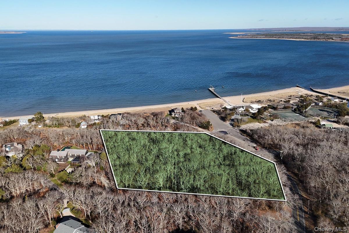 Aerial view of property and surrounding area featuring property parcel outlined and a nearby body of water