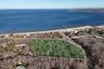 Aerial view of property and surrounding area featuring property parcel outlined and a nearby body of water