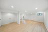 Below grade area featuring light wood finished floors, recessed lighting, and baseboard heating
