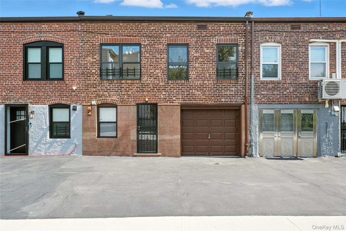 View of front of house featuring brick siding and a garage