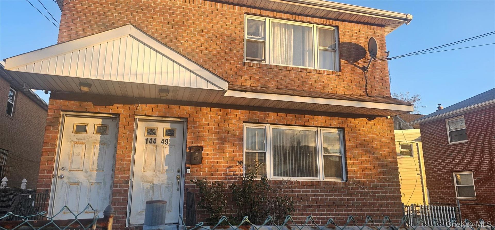View of front of house featuring brick siding and a porch