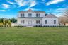 View of front of property with covered porch, roof with shingles, and board and batten siding. For Marketing Purposes!
