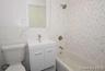 Bathroom with vanity, shower / tub combination, and tile walls