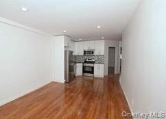 Unfurnished living room with dark wood finished floors and recessed lighting