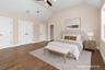 Bedroom with lofted ceiling, wood finished floors, a ceiling fan, and multiple closets