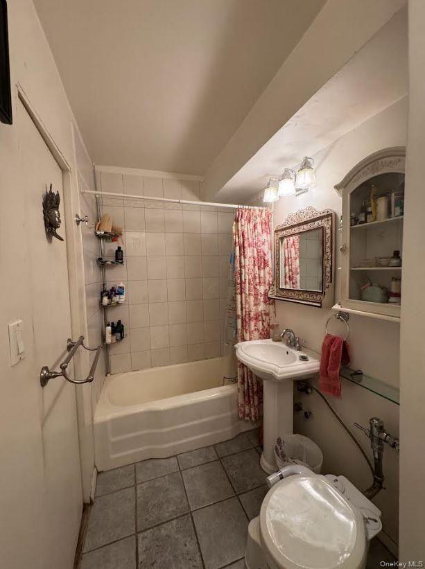Full bath featuring shower / bath combination with curtain and tile patterned flooring