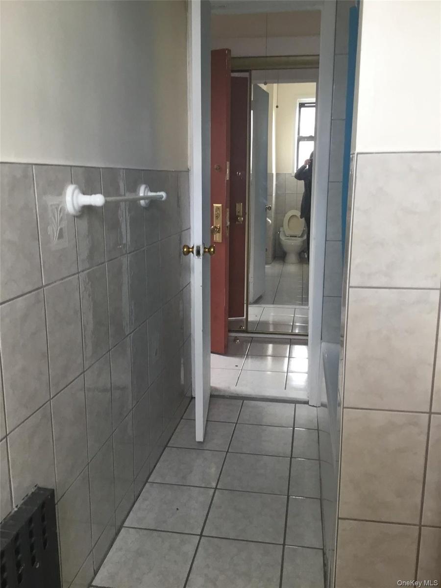 Bathroom with tile walls, tile patterned flooring, and wainscoting