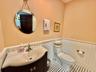 Half bathroom with wainscoting and vanity