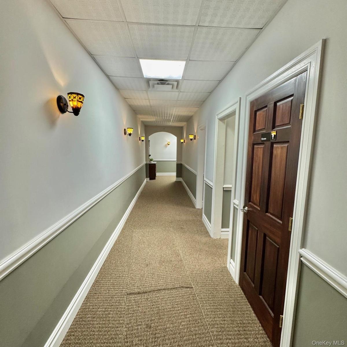 Hallway featuring carpet floors and a paneled ceiling