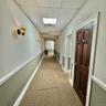 Hallway featuring carpet floors and a paneled ceiling
