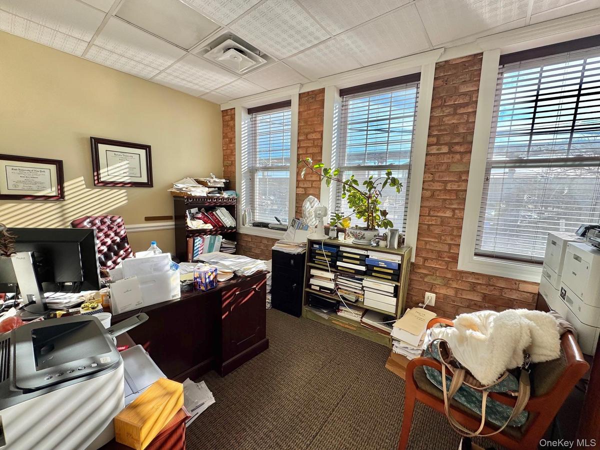Home office with brick wall and a paneled ceiling