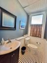 Half bath with wainscoting, vanity, and an ornate ceiling