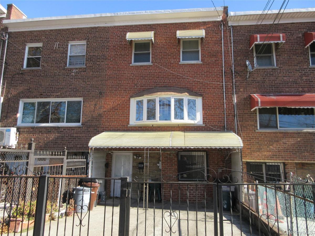 Traditional-style home featuring a fenced front yard, brick siding, and a gate