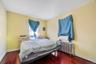 Bedroom with radiator heating unit, dark wood-type flooring, and cooling unit