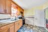 Kitchen with gas stove, light stone counters, and under cabinet range hood