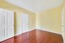 Unfurnished bedroom featuring baseboards and dark wood-type flooring