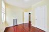 Unfurnished bedroom featuring radiator heating unit and dark wood-style flooring