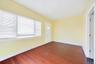 Spare room featuring dark wood-style flooring and baseboards