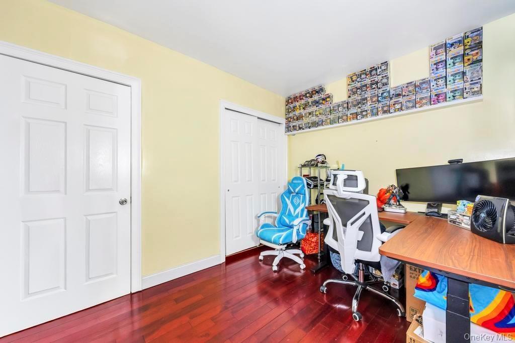Home office with dark wood-style flooring and baseboards