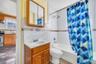 Full bathroom featuring shower / bath combo, vanity, backsplash, and tile walls