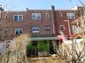Rear view of property featuring brick siding and a chimney