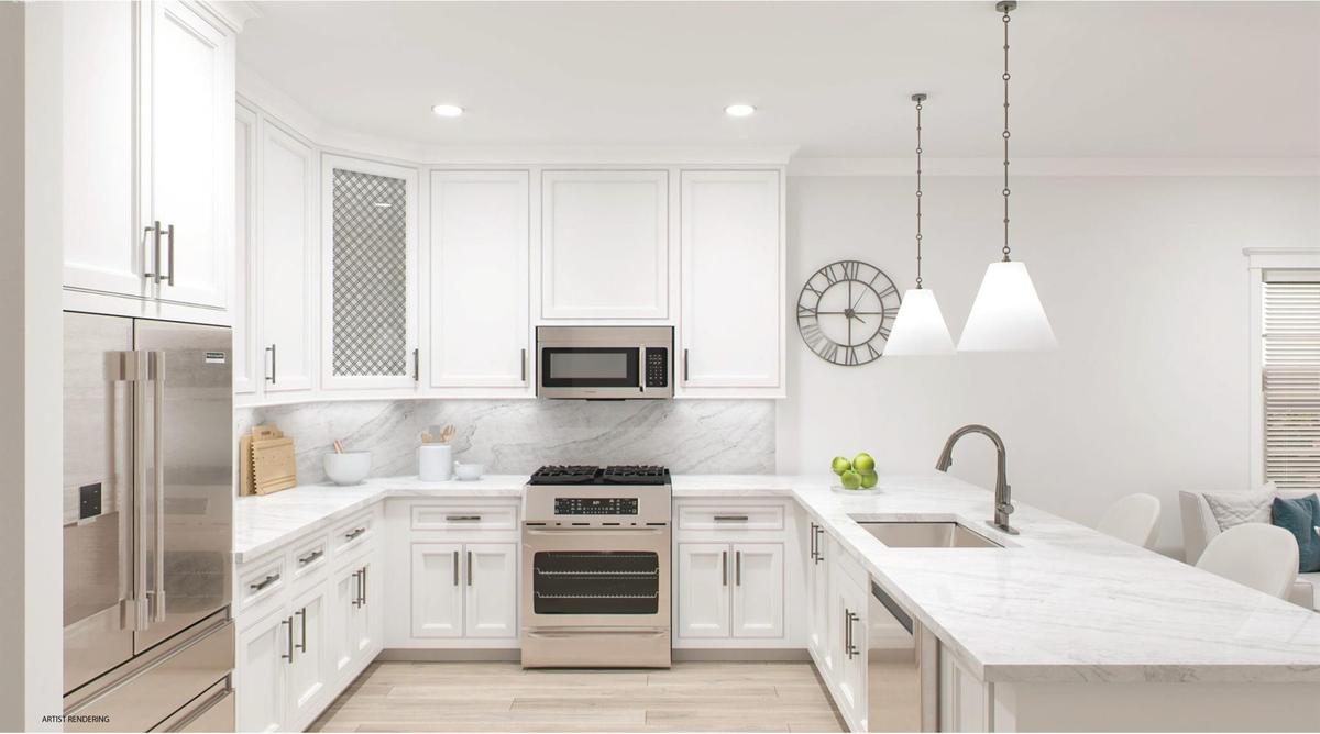 Kitchen with a peninsula, a sink, white cabinets, appliances with stainless steel finishes, and decorative light fixtures