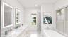 Full bath with double vanity, a soaking tub, a sink, and recessed lighting